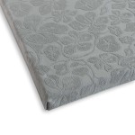 Prześcieradło żakardowe bez gumki 150x205 w kolorze szarym, prezentujące subtelny wzór roślinny. Ujęcie z boku, pokazujące złożony materiał, o teksturowanej powierzchni. Produkt leży na jasnym tle, co podkreśla jego detale.