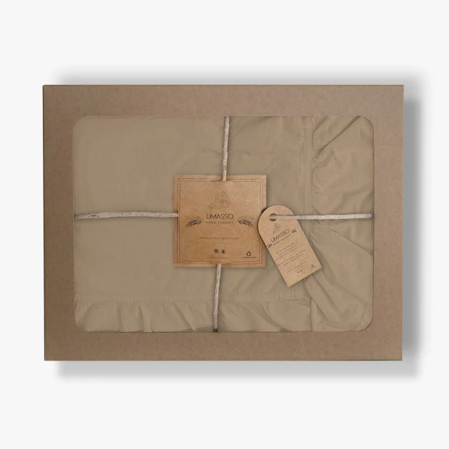Pościel bawełniana z falbanką 220x200 w kolorze beżowym, opakowana w kartonowe pudełko z przezroczystą szybą. Widoczne metki z nazwą marki LIMASSO oraz informacjami o produkcie. Zestaw wiązany naturalnym sznurkiem.