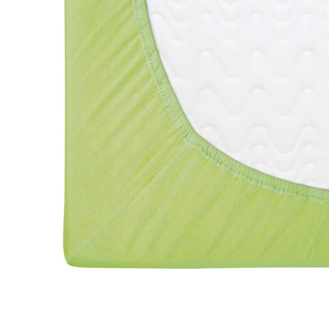 Prześcieradło jersey z gumką w kolorze limonkowym, o wymiarach 90x200 cm. Zbliżenie na krawędź produktu, ukazujące elastyczną gumkę oraz teksturę materiału, dopasowanego do materaca.