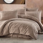 Pościel satyna bawełniana 180x200 w kolorze jasnobrązowym z delikatnym wzorem w kratę. Zestaw zawiera poszewki na poduszki oraz kołdrę, ułożony na łóżku, w otoczeniu stonowanego tła.