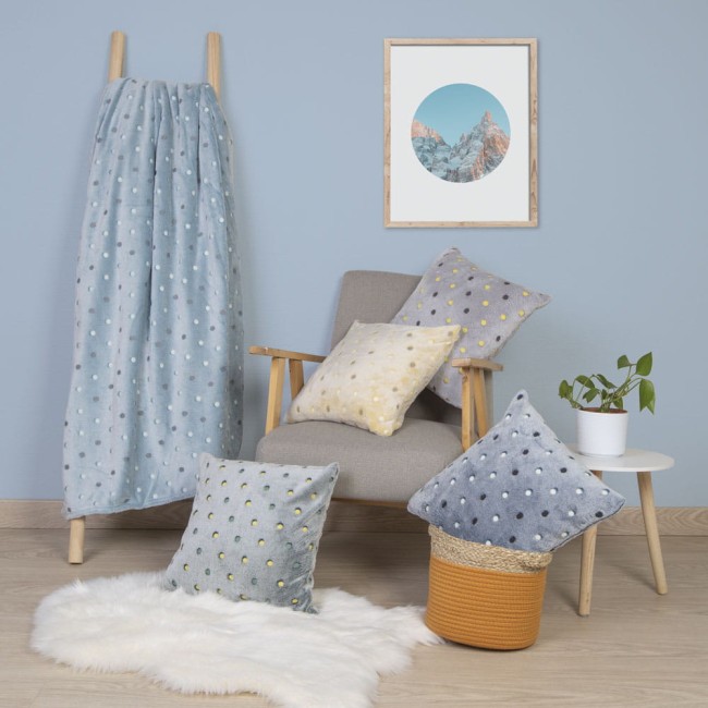 Poszewka mikrofibra 40x40 w kolorze navy z wzorem w neonowe kropki. Ujęcie frontalne przedstawia poduszkę na sofie w aranżacji wnętrza, obok innych poduszek. Tło w jasnym, jednolitym kolorze, dodaje elegancji. Produkt leży na sztucznej puchowej narzucie.