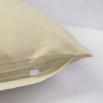 Poszewka satynowa 70x80 w kolorze kremowym, leżąca na jasnym tle, z widocznym zamkiem błyskawicznym. Materiał gładki, z delikatnym połyskiem, podkreślający elegancki wygląd. Odpowiednia do poduszki o wymiarach 70x80 cm.