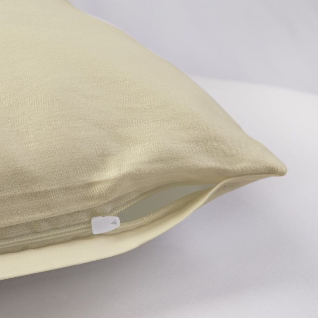 Poszewka satynowa 70x80 w kolorze kremowym, leżąca na jasnym tle, z widocznym zamkiem błyskawicznym. Materiał gładki, z delikatnym połyskiem, podkreślający elegancki wygląd. Odpowiednia do poduszki o wymiarach 70x80 cm.