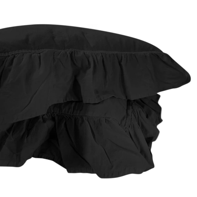 Pościel bawełniana z falbanką w kolorze czarnym, rozmiar 160x200. Ujęcie w zbliżeniu na górną część narzuty, ukazujące falbankę i teksturę materiału. Produkt leży na jednolitym tle, prezentując elegancki, minimalistyczny styl.