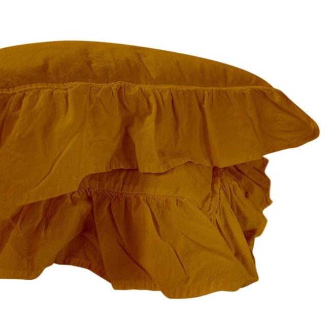 Pościel bawełniana z falbanką w kolorze musztardowym, rozmiar 160x200, widoczna w zbliżeniu z boku. Falbanka zdobi krawędź, a materiał ma gładką fakturę. Produkt leży płasko, ukazując swój unikalny detal. Białe tło podkreśla kolor poszewki.
