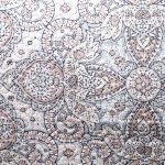 Drukowana narzuta Harem 170x210, w delikatne wzory kwiatowe w odcieniach szarości i różu, z wyraźną teksturą. Produkt leżący na płaskiej powierzchni, prezentujący detale wzoru oraz subtelne złote akcenty, na jasnym tle.