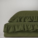 Pościel bawełniana z falbanką w kolorze oliwkowym, rozmiar 160x200, leżąca na białym tle. Widoczne marszczenia falbanki na kołdrze oraz poduszce, matowa tekstura materiału. Prosty i estetyczny design, bez wzorów i dodatków.
