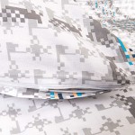 Pościel bawełniana 220x200 w odcieniach szarości z wzorem w kratkę. Zbliżenie na poszewkę z zamkiem, ułożoną na tle gładkiego materiału. Widoczne kolorowe akcenty w odcieniach niebieskiego i pomarańczowego. Matowa tekstura, nowa, idealna do sypialni.