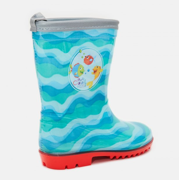 Kalosze dziecięce Cool Kids, rozmiar 28, kolor błękitny z falistym wzorem. Stoją w pozycji pionowej, widok z boku. Posiadają czerwony bieżnik, a z przodu logo z przyjaznymi rybkami. Górna krawędź jest wykończona szarym materiałem.