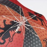 Parasol dziecięcy Harry Potter, w czerwonym kolorze, z wzorem przedstawiającym czarne lwy oraz gwiazdki. Ujęcie z dołu, ukazujące wnętrze czaszy i mechanizm otwierania. Elementy metalowe w białej obudowie oraz plastikowy uchwyt.