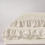 Komplet poszewek bawełnianych z falbanką w kolorze białym, o wymiarach 40x40 cm, leżących płasko na jasnym tle. Materiał w odcieniu śnieżnobiałym z widoczną falbanką i lekką teksturą. Brak widocznych napisów lub logo.