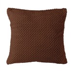 Poszewka żakardowa w kolorze mlecznej czekolady o wymiarach 40x40 cm. Wykonana z teksturowanego materiału, z charakterystycznym plecionym wzorem. Produkt leży na jednolitym tle, ukazując detale tkaniny i kształt poduszki.