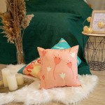 Poduszka przytulanka Panna 40x40 w kolorze brzoskwiniowym z graficznym wzorem kwiatów. Ułożona na białym futerku, w tle zielona narzuta i dekoracyjna wisząca ramka. Produkt leży płasko, z widocznymi detalami w postaci pąków tulipanów.