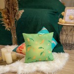 Poduszka przytulanka Waga 40x40 w kolorze zielonym, pokryta wzorem w liście w odcieniach żółtego i niebieskiego. Ułożona na podłodze na sztucznej wsypie, obok świec w metalowym świeczniku. Tło z zielonym narzutą na łóżko.