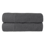 Ręcznik bawełniany 50x90 cm w kolorze ciemnym popiel, leżący na płasko. Widoczny wzór w formie drobnej siatki na jednym końcu. Tekstura jest gładka i miła w dotyku. Tło jest jednolite, co podkreśla kolor ręcznika.