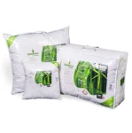 Kołdra całoroczna 200x220 cm w białym pokryciu, antyalergiczna, wykonana z mieszaniny bambusa i bawełny. Ułożona poziomo obok poduszki. Widoczne zielone elementy opakowania i logo Bamboo & cotton. Rozmiar i istotne informacje na etykietach.