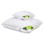 Poduszka antyalergiczna pikowana w rozmiarze 50x60 cm, wykonana z materiału Bamboo. Ułożona poziomo, w dwóch warstwach. Kolor biały z zielonymi akcentami. Widoczny detal logo oraz etykiety, przedstawiająca właściwości produktu.