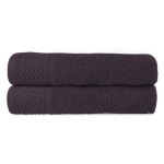 Komplet ręczników z bawełny Solano w eco pudełku, w kolorze ciemnofioletowym, z widocznym teksturowanym wzorem na brzegach. Ręczniki leżą jeden na drugim, układając się w złożony stos. Produkt wykonany z miękkiego materiału o wysokiej chłonności.