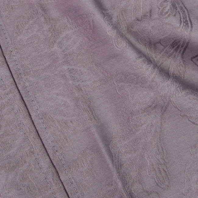 Fioletowa pościel satyna bawełniana żakardowa w rozmiarze 160x200, z subtelnym, wyraźnym wzorem florystycznym. Widok z bliska, ukazujący detal szycia i fakturę materiału. Elegancka, matowa struktura.