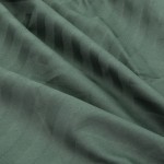 Pościel satyna bawełniana żakardowa w kolorze zielonym, wykonana z delikatnej tkaniny. Zbliżenie na materiał ukazuje strukturalny wzór w formie pasków. Tkanina jest miękka w dotyku i lekko połyskująca, co podkreśla jej elegancki charakter.
