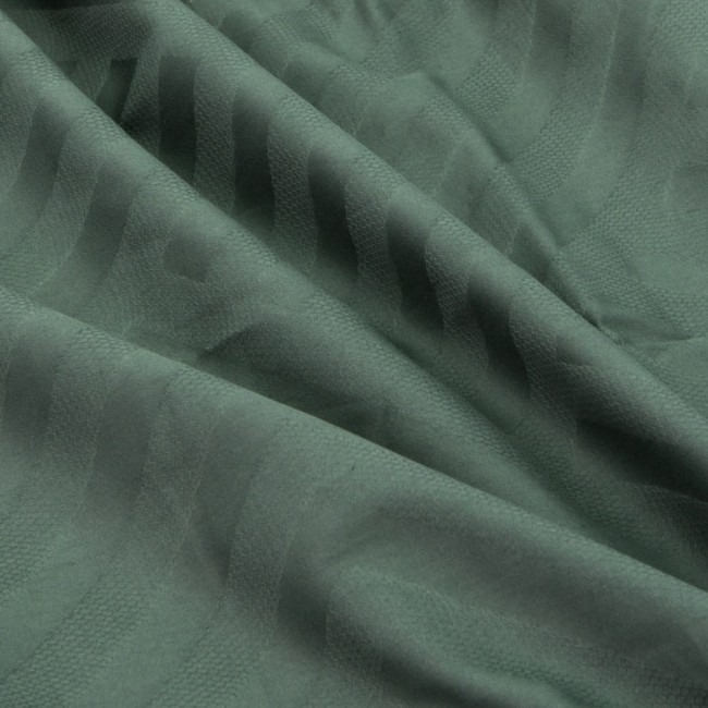 Pościel satyna bawełniana żakardowa w kolorze zielonym, wykonana z delikatnej tkaniny. Zbliżenie na materiał ukazuje strukturalny wzór w formie pasków. Tkanina jest miękka w dotyku i lekko połyskująca, co podkreśla jej elegancki charakter.