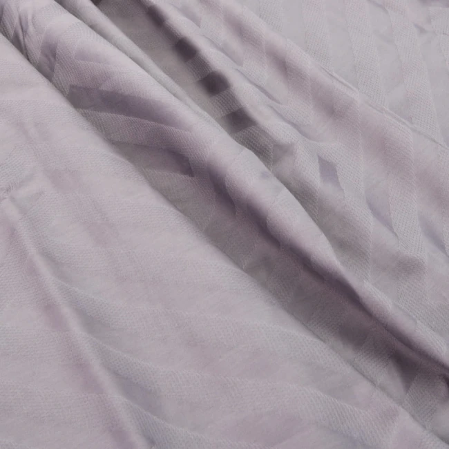 Pościel satyna bawełniana żakardowa 160x200 w odcieniach szaro-fioletowych, z widocznym wzorem diagonalnych linii. Produkt rozłożony na płasko, ukazujący teksturę tkaniny. Przeznaczony do łóżka, pasujący do standardowych rozmiarów poduszek i kołder.