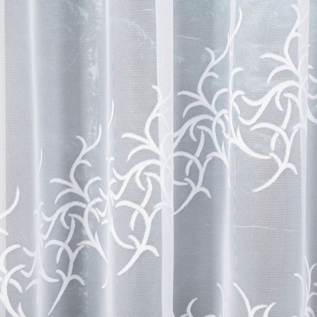 Firana żakardowa Bakaro w kolorze białym, o wymiarach 520x160 cm, z delikatnym, ażurowym wzorem w formie gałązek. Materiał lekki i transparentny, zawieszona w sposób rozłożony, na jednolitym tle.