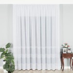 Firana haftowana ze wzorem pasowym, wysokość 280 cm, w kolorze białym. Produkt wiszący, z delikatnym haftem na dolnej krawędzi. Tło w odcieniach szarości z rośliną doniczkową po lewej stronie oraz stolikiem z kwiatami po prawej.