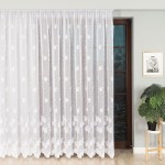 Firana żakardowa w białym kolorze z wzorem liści, o wysokości 250 cm, wisząca w oknie. Zbliżenie na szczegóły wzoru i teksturę materiału. W tle widać drewniane drzwi oraz roślinę w doniczce, co podkreśla aranżację wnętrza.