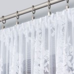 Firana żakardowa w kolorze białym, wysokość 250 cm, z delikatnym wzorem kwiatowym, zawieszona na metalowym karniszu. Zbliżenie na fakturę, z miętowymi plisami, tworzy subtelne wrażenie lekkości i elegancji.