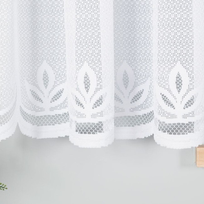 Firana gotowa Pola żakardowa w kolorze białym, o wymiarach 500x160 cm. Wzór z delikatnymi liśćmi na dolnej krawędzi. Produkt wiszący, wykonany z tekstylnego materiału o ażurowej fakturze, idealny do wypełnienia okna w jasnym wnętrzu.