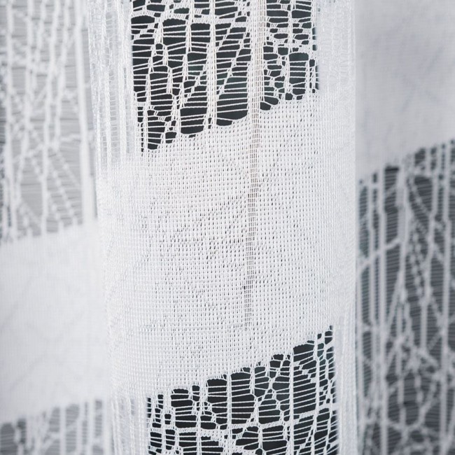 Firana żakardowa Wiktoria w białym kolorze, o wymiarach 410x160 cm, z delikatnym wzorem w formie geometrycznych linii. Produkt wisi w delikatnych fałdach, na jednolitym tle.