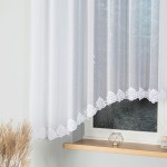 Firana żakardowa w kolorze białym, o wymiarach 400x160 cm, z delikatnym wzorem i koronkową falbanką na dolnej krawędzi. Produkt wiszący na oknie, w tle widoczna drewniana parapet i roślinność.
