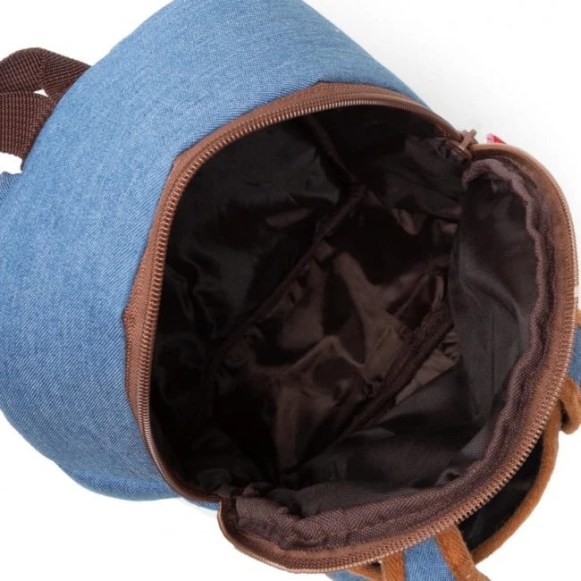 Otwarty pluszowy plecak dziecięcy z maskotką jednorożca, wykonany z błękitnego materiału zewnętrznego. Wnętrze w ciemnym kolorze, zapewniające dodatkową przestrzeń do przechowywania. Ujęcie z góry, z widoczną szaro-brązową taśmą zamka.