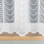 Firana żakardowa w kolorze białym, o wysokości 155 cm, z delikatnym wzorem pasowym. Zakończona falbana, wykonana z przejrzystego materiału, pokazująca subtelne detale wzoru. Produkt wiszący, umieszczony na tle naturalnego drewna.