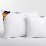 Poduszka antyalergiczna pikowana 50x70 cm w białej poszewce z wzorem szaro-białych kratek. Ułożona leżąco, z widocznym logo w rogu, zapewnia komfort i wsparcie. W tle jednolite, jasne. Druga, mniejsza poduszka obok.