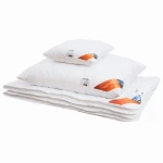 Poduszka antyalergiczna pikowana 50x70 cm, leżąca na białym tle. Widoczne dwa mniejsze poduszki ułożone na większej. Wszędzie widoczny biały materiał, z delikatnym pikowaniem. Etykiety z logo oraz oznaczeniami kolorystycznymi. Brak innych dekoracji.