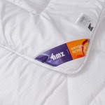 Kołdra całoroczna 155x200 cm w kolorze białym, wykonana z materiałów antyalergicznych. Złożona, z prostym wzorem w kratę. Widoczna etykieta z logo „amz” oraz napisem „ANTYSTRES ACTIVE” w odcieniach fioletu i pomarańczy.