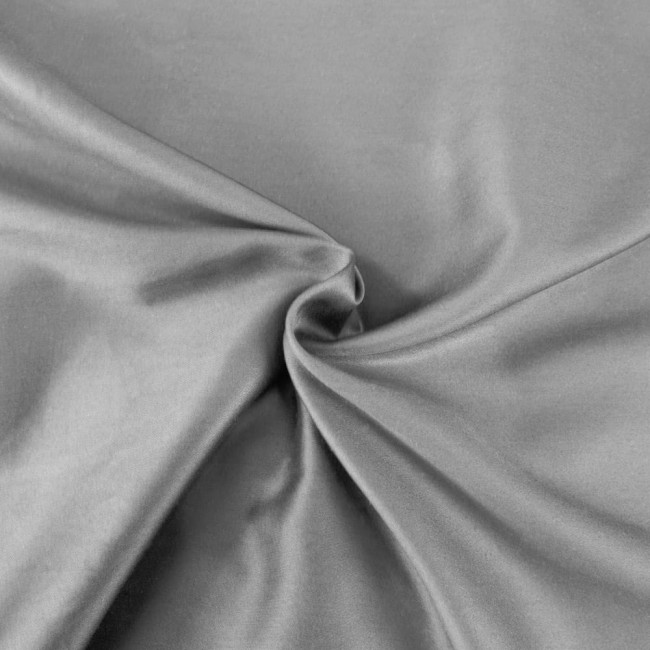 Pościel satyna bawełniana w kolorze popielatym, rozłożona na gładkiej powierzchni. Wykonana z delikatnego materiału, z widoczną, subtelną teksturą. Zdjęcie w zbliżeniu ukazuje detale tkaniny. Rozmiar 140x200 cm.
