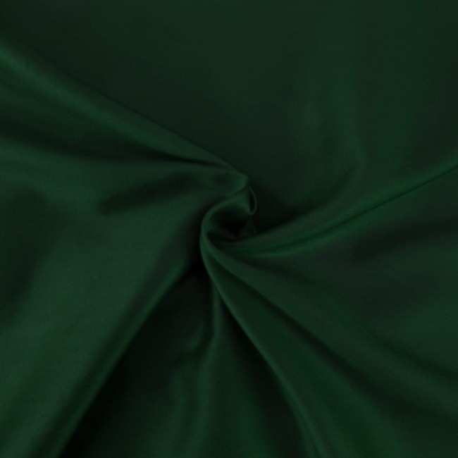 Pościel satyna bawełniana w kolorze butelkowej zieleni, materiał gładki i błyszczący. Na zdjęciu widoczne złożenie tkaniny, ukazujące jej miękkość i intensywność koloru. Produkt idealny do aranżacji sypialni.