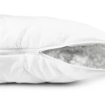 Poduszka antyalergiczna 50x70 Classic pikowana. Biała, z zapięciem na zamek błyskawiczny, z widoczną, miękką wypełnieniem. Ujęcie z boku, pokazujące detal zszycia i fakturę tkaniny. Produkt leży na jednolitym, białym tle.