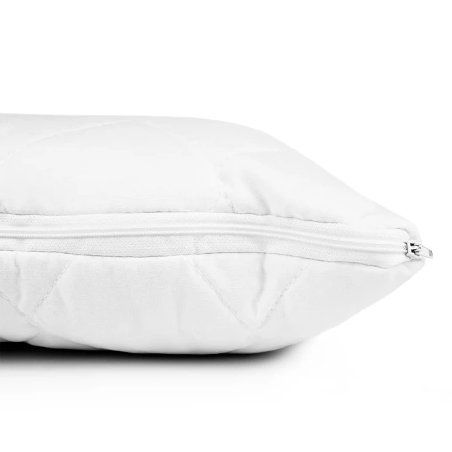 Poduszka antyalergiczna 50x70 Classic, pikowana, w kolorze białym, z widocznym zamkiem błyskawicznym. Ujęcie z boku, poduszeczka leży na płaskiej powierzchni.