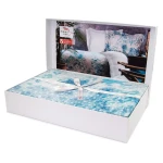 Pościel satyna bawełniana 220x200 Luxury Premium Belize w kolorze niebieskim i białym, zapakowana w białe pudełko z przezroczystym wiekiem, ułożona na płasko, z delikatną wstążką.