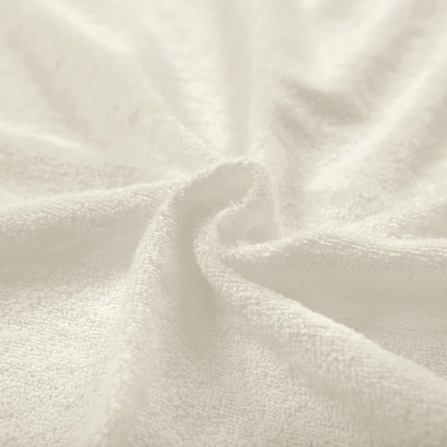 Pościel frotte 200x220 w kolorze ecru, wykonana z miękkiej, teksturowanej tkaniny. Widok zbliżeniowy na rozwiniętą tkaninę, podkreślający jej gładką, przyjemną w dotyku powierzchnię i wysoką jakość.