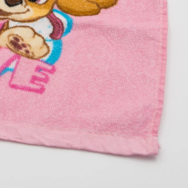 Różowy ręcznik bawełniany dziecięcy 30x30 cm z postacią Skye z Psi Patrol. Wzór przedstawia Skye w kolorze brązowym i błękicie. Ręcznik leży płasko na białym tle, ukazując detale tkaniny i haftu na krawędzi.