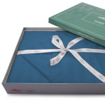 Pościel bambusowa satyna bawełniana 160x200 w kolorze chabrowym, z delikatnymi paskami, zapakowana w eleganckie pudełko. Złożona i przewiązana białą wstążką z napisem Luxury Collection na górze. Widoczna logo producenta.