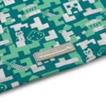 Plecak dziecięcy worek Minecraft w zielonym kolorze, z wzorem pixelartowym w odcieniach zieleni i srebra. Widoczna etykieta z logo Minecraft. Ujęcie z boku, ukazujące gładką fakturę materiału. Produkt jest zwinięty, co podkreśla jego kompaktowy kształt.