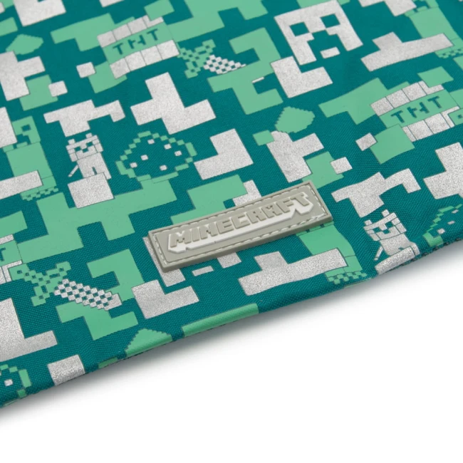 Plecak dziecięcy worek Minecraft w zielonym kolorze, z wzorem pixelartowym w odcieniach zieleni i srebra. Widoczna etykieta z logo Minecraft. Ujęcie z boku, ukazujące gładką fakturę materiału. Produkt jest zwinięty, co podkreśla jego kompaktowy kształt.