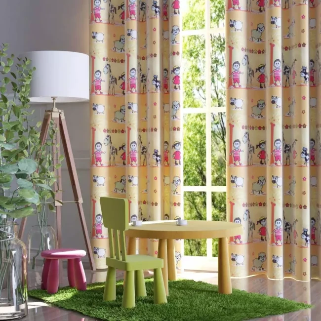 Dekoracyjna drukowana tkanina zasłona Baranek w odcieniach żółci z kolorowymi wzorami dziecięcych postaci i zwierząt. Tkanina wisząca na oknie w pokoju dziecięcym, z roślinnością w donicach i meblami w jasnych, pastelowych kolorach.