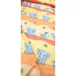 Dekoracyjna zasłona z drukowanej tkaniny w odcieniu żółtym, z motywem zwierząt, w tym słoni i zebry. Wzór na tle w kolorze jasnopomarańczowym, z zielonymi elementami liści. Zasłona leży w rozłożonej pozycji, zbliżenie na detale.